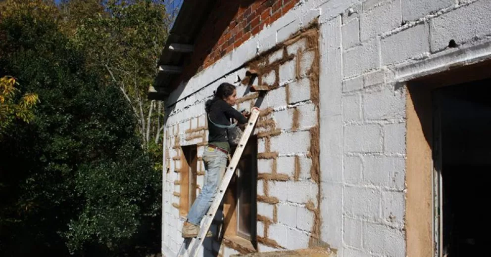 El trabajador aplicando pintura impermeabilizante a la pared del